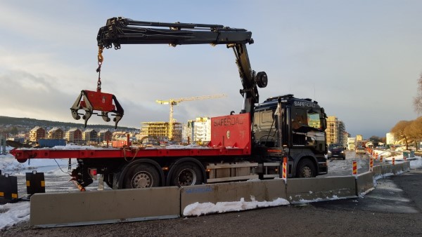 Bild på kranbil som lyfter av betongblock