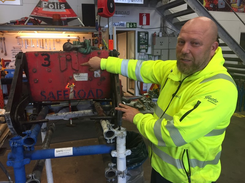 Man vid lyftsax för tunga betongblock