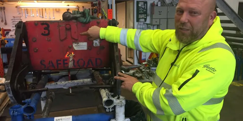 Man vid lyftsax för tunga betongblock