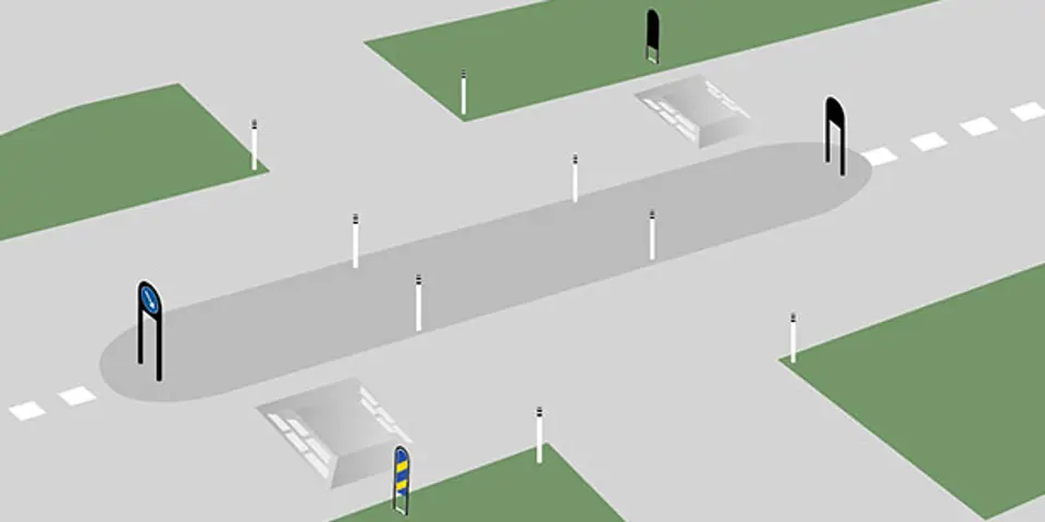 Bilden visar en övergångspassage som säkras upp med hjälp av vägkudde, skyltbågar och pollare