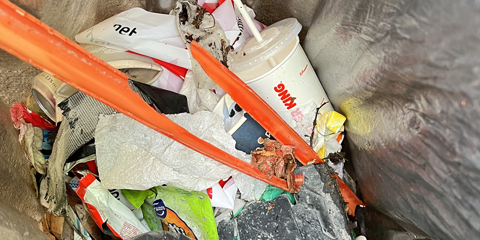 Skräp i en grå sopsäck