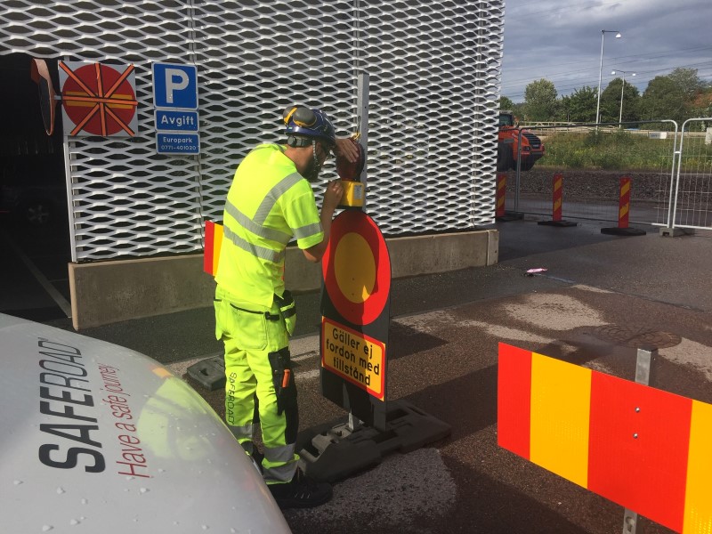 Man justerar till varningslykta på trafikavstängningsmaterial