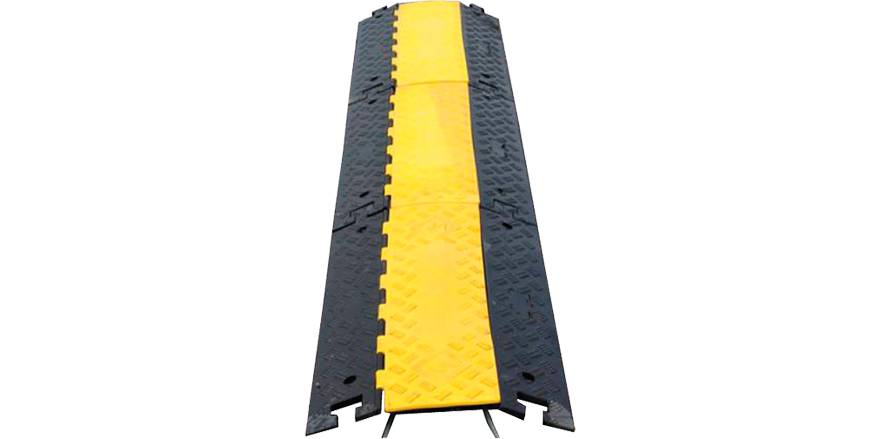 Svart och gult gummiskydd som skyddar kablar på vägen