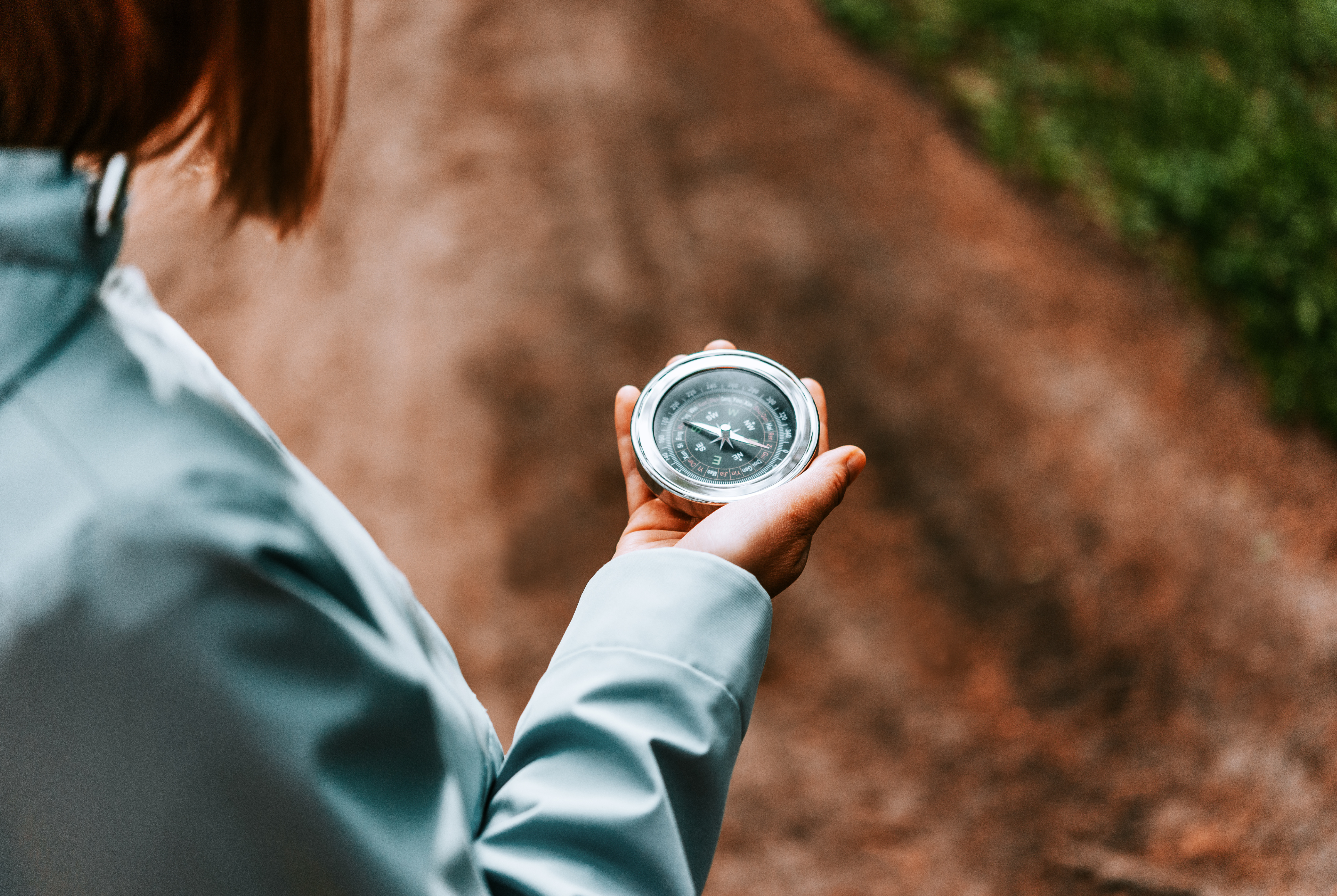 Närbild på en person som håller en kompass i sin hand