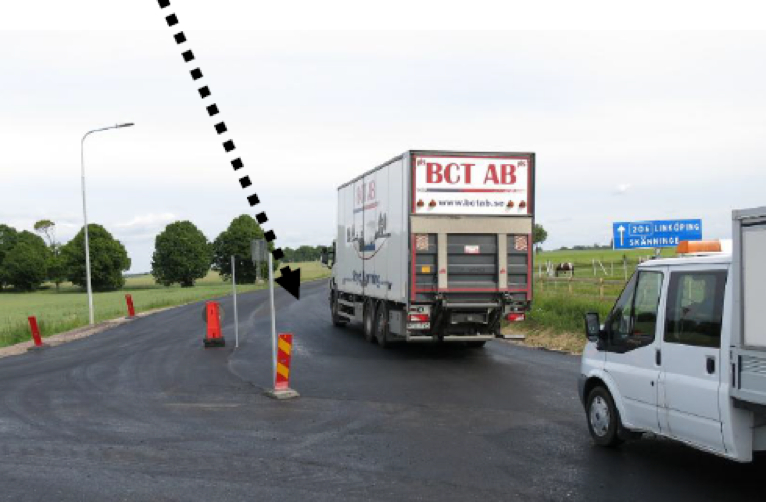 Bilar som kör på nyasfalterad väg med vägmärken som leder dem