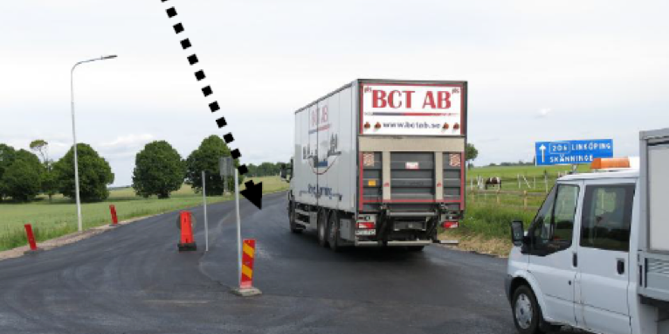 Bilar som kör på nyasfalterad väg med vägmärken som leder dem