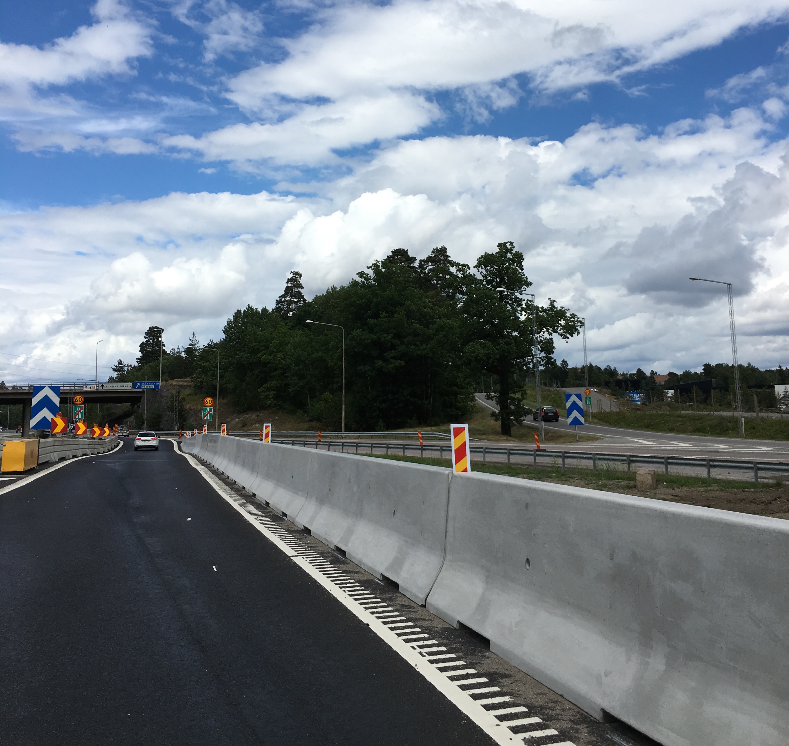 Bild av en väg där en skyddsbarriär i betong separerar körfälten.
