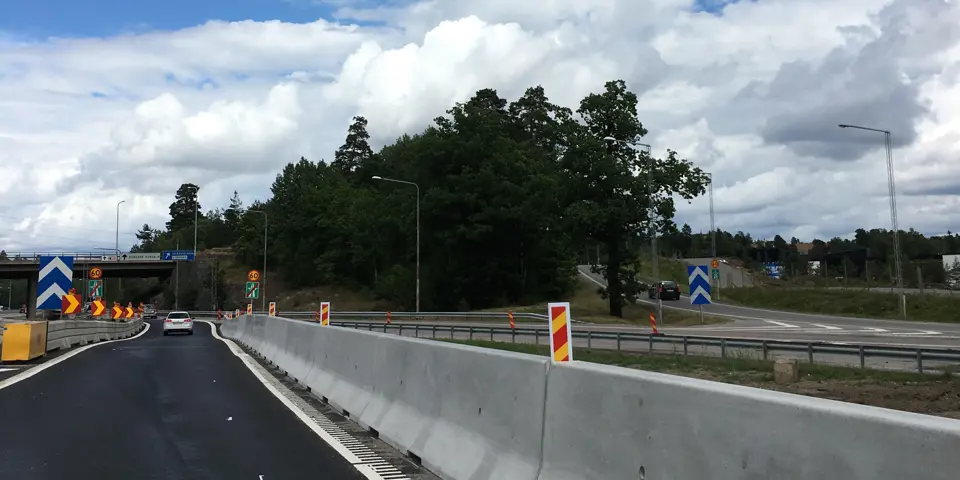 Bild av en väg där en skyddsbarriär i betong separerar körfälten.