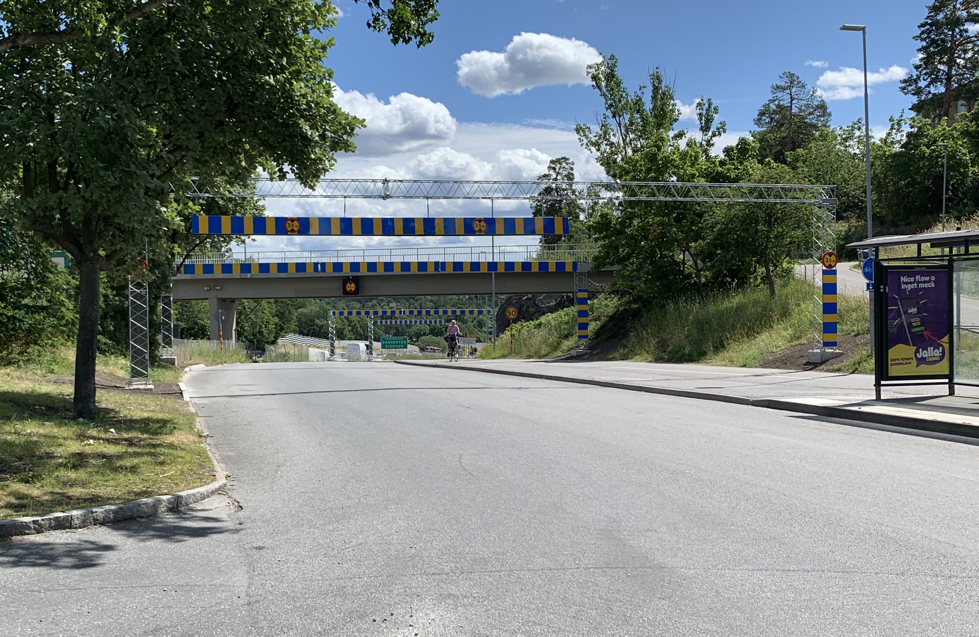 Höjdhinderportal med gul och blå reflex över en bilväg