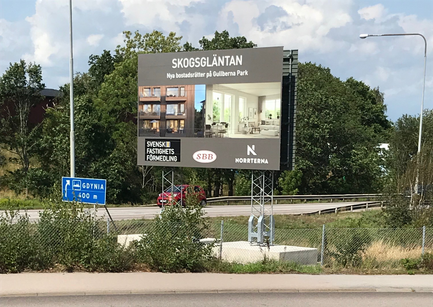 Byggskylt med information som är placerad invid en väg