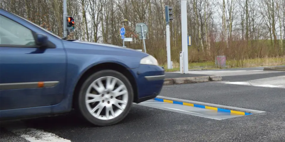 Bil kör fram emot ett hastighetssänkande farthinder kallat Actibump