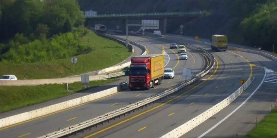 En trafikerad väg med mitträcke och skyddsbarriärer.