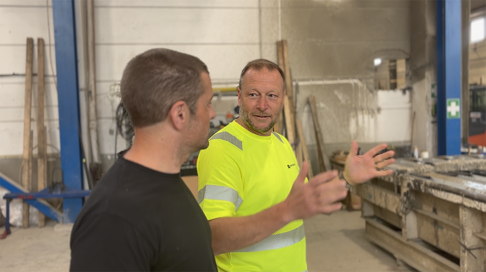 Två manliga medarbetare på ett gjuteri diskuterar