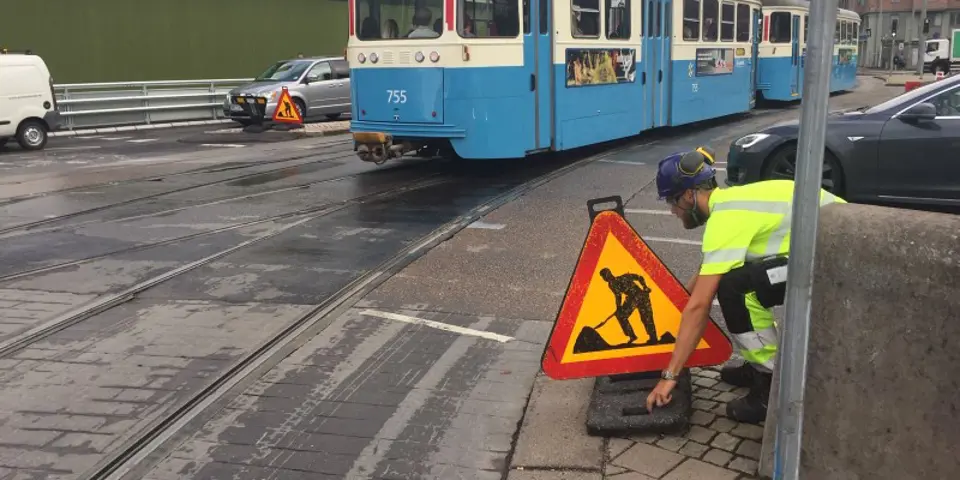 Man justerar en varningsskylt som hamnat snett