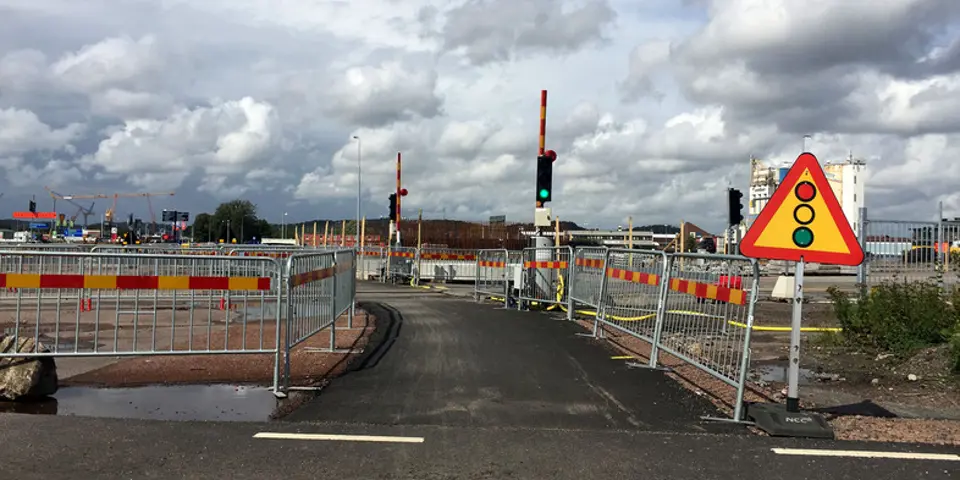 Byggarbetsplats med kravallstaket som skapar en asfalterad promenadväg