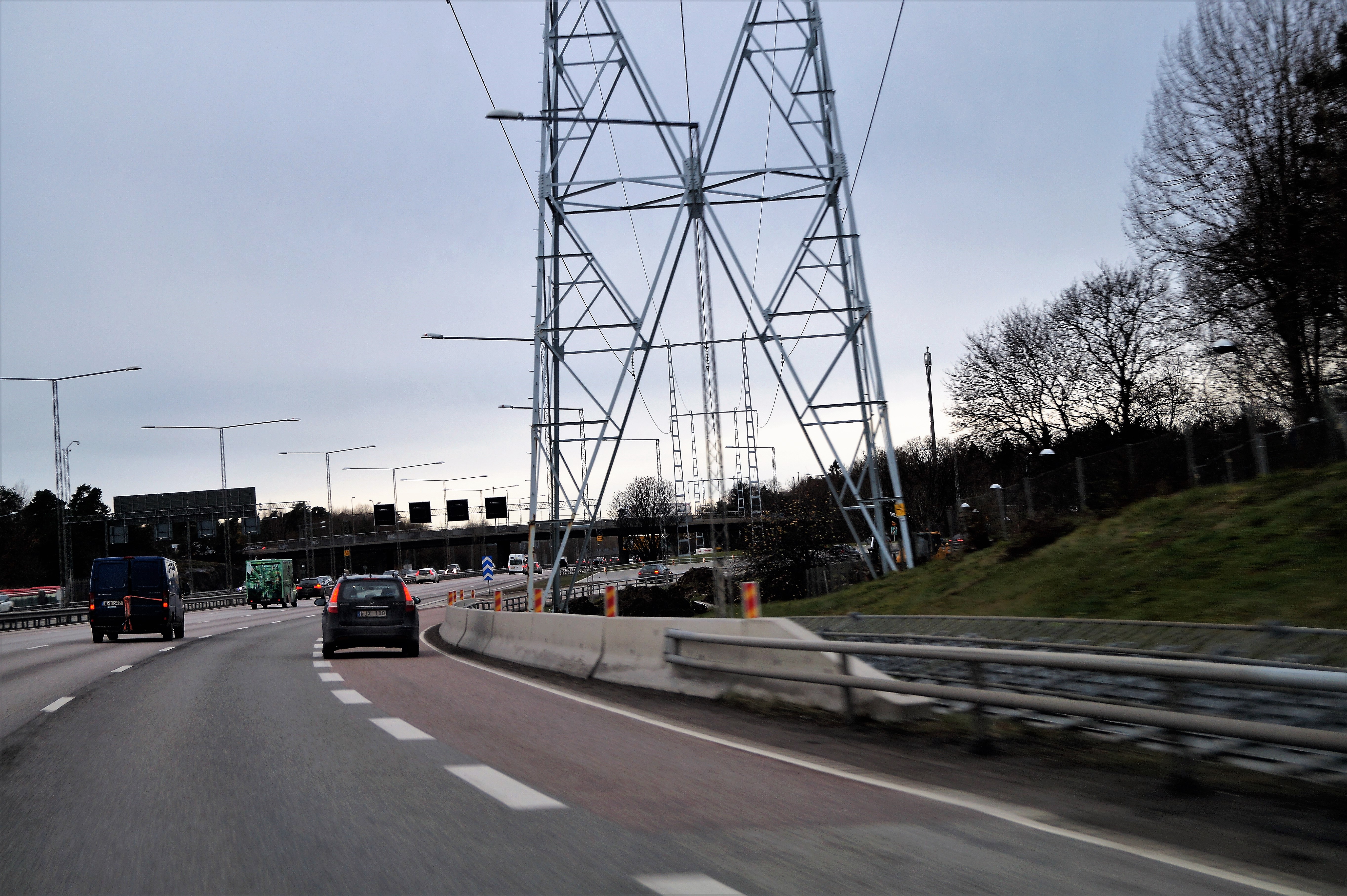 En trafikerad väg med en skyddsbarriär i betong till höger om körfältet