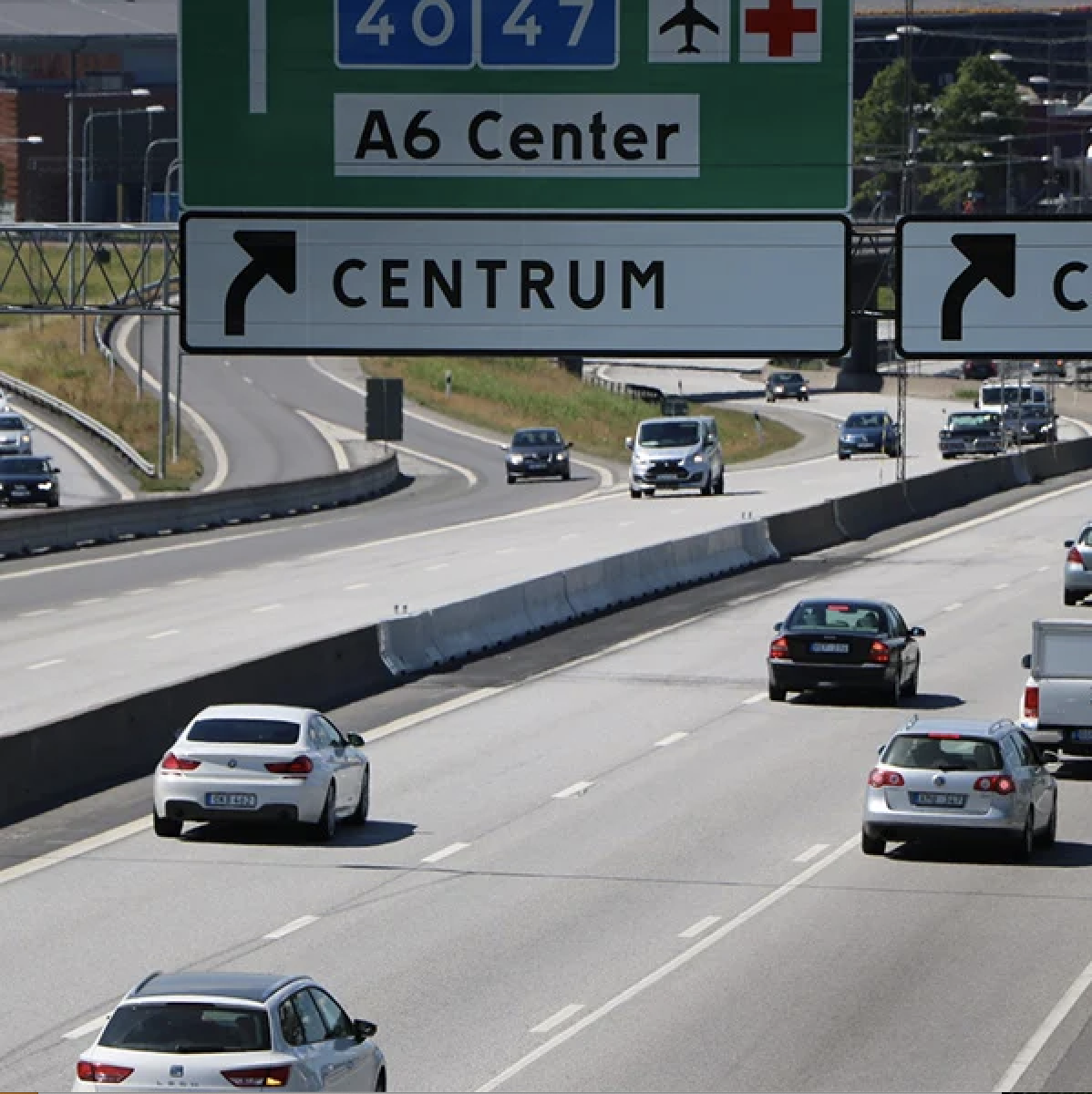 Bilden visar bilar på en motorväg som kör förbi en betongbarriär 