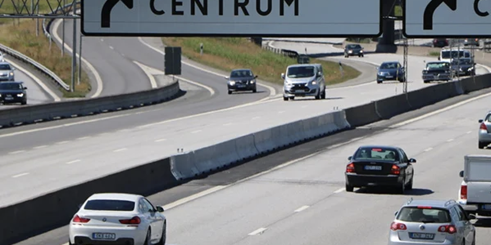 Bilden visar bilar på en motorväg som kör förbi en betongbarriär 