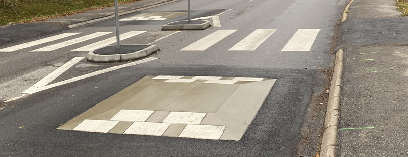 Bild på ett permanent farthinder i betong som ligger framför ett övergångsställe
