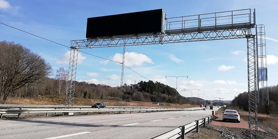 Portal med en stor digital skylt över en väg